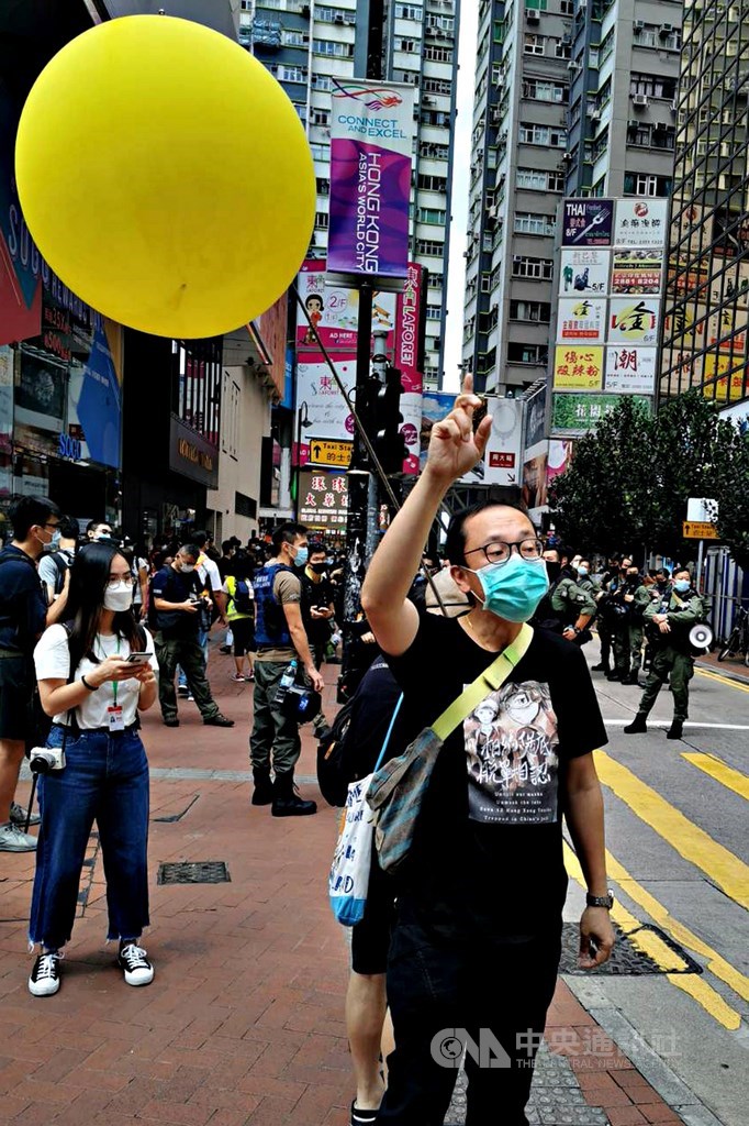 香港有網友發起1日於中國「國慶」當天在多區遊行,圖為銅鑼灣崇光(SOGO)百貨前,一名示威者高舉代表「反送中」運動的黃氣球。中央社記者張謙香港攝 109年10月1日