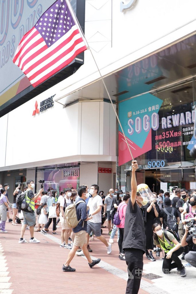 香港有網友發起1日於中國「國慶」當天在多區遊行,圖為一名「反送中」運動示威常客,在銅鑼灣街頭高舉美國國旗。中央社記者張謙香港攝 109年10月1日