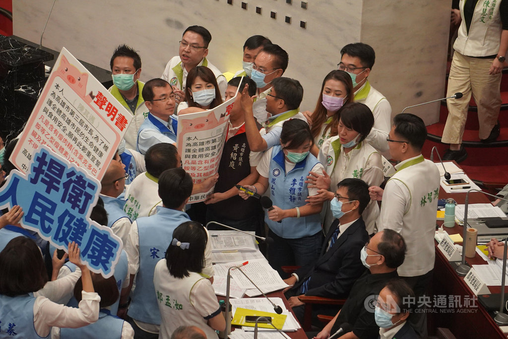 高雄市議會第3屆第4次定期大會7日開議,市長陳其邁(中排右3)首次率團隊列席備詢,國民黨團10多名議員拿出一份禁止萊豬進高雄聲明書趨前走向市長備詢席,堅持要陳其邁簽署。中央社記者董俊志攝 109年10月7日