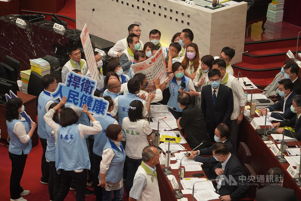 高雄市議會第3屆第4次定期大會7日舉行,國民黨團10多名議員拿出一份禁止萊豬進高雄聲明書趨前走向市長備詢席,堅持要市長陳其邁簽署,但陳其邁未加理會,隨後民進黨議員趨前解圍,議事廳內亂成一團。中央社記者董俊志攝 109年10月7日