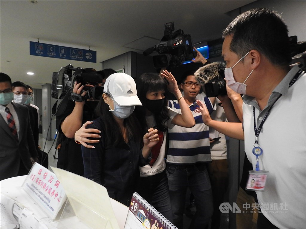 康軒文教集團疑藉「吹哨者」事件施壓女員工離職風波,勞資爭議調解會12日於新北市政府召開,協調約2小時才達成和解。女員工(戴帽者)在議員陪同下步出協調室。中央社記者沈佩瑤攝 109年10月12日