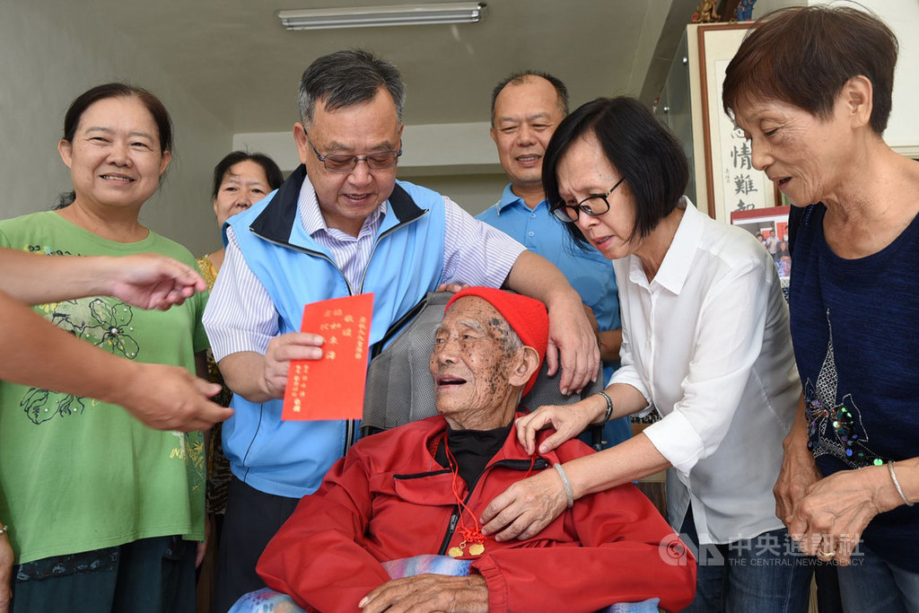 澎湖全縣百歲人瑞有26人,縣長賴峰偉(前左2)15日前往探視長者,並致贈敬老禮金、衛福部金鎖片和總統敬老狀,祝福長者身體健康「呷百二」。中央社 109年10月15日