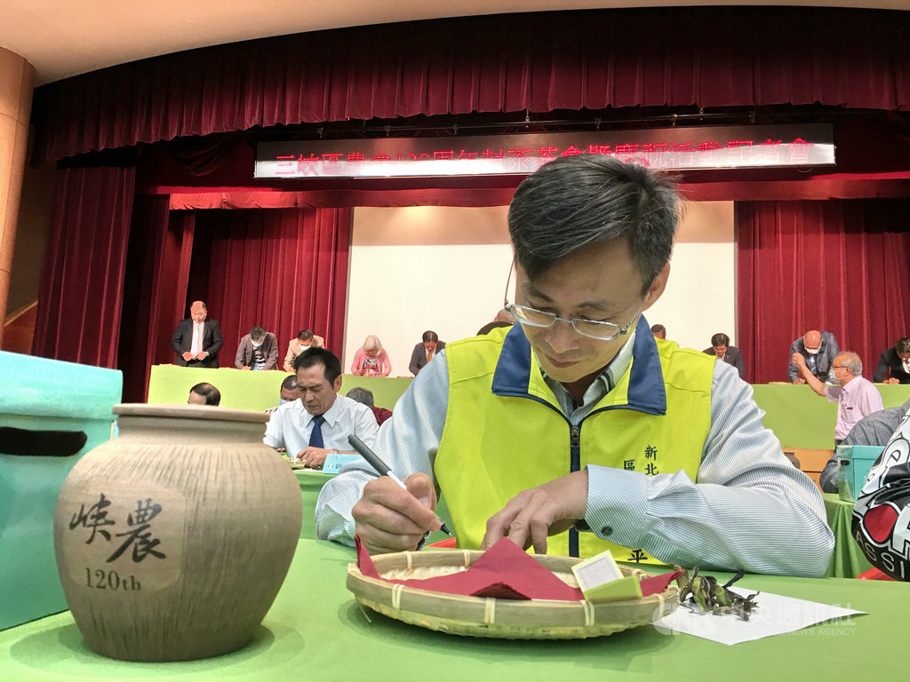 新北市三峽區農會16日歡慶120歲生日,並舉行「封茶」許願儀式,將白茶存放在陶製茶罐中,7年後再啟封,三峽區長周晉平(前)專注在卡片上寫下未來願望與祝福。中央社記者黃旭昇新北市攝 109年10月16日