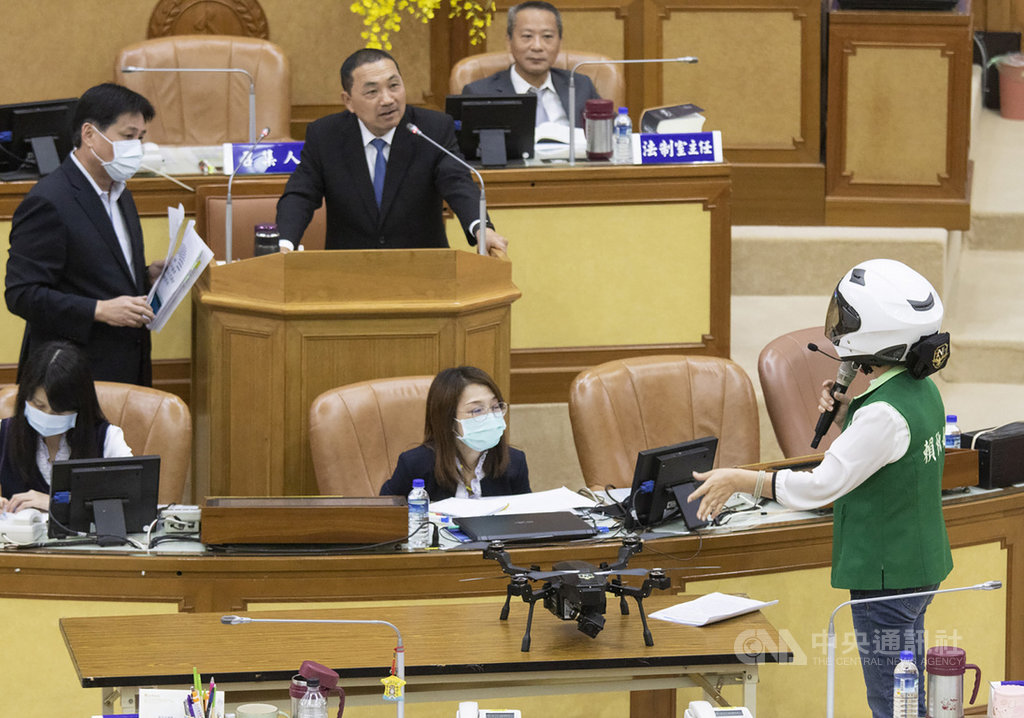 新北市議會20日進行市政總質詢時,民進黨籍議員賴秋媚(前右)戴起預計推行的「警蜂動態影像蒐集機及辨識系統1.0」智慧頭盔質詢市長侯友宜(後左2),質疑新北推動的科技防衛城2.0能否增加破案率,又或是造成員警負擔。中央社記者王鴻國攝 109年10月20日