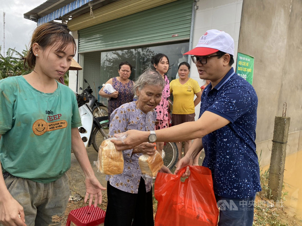 至善基金會越南順化工作站主任黃仲始(右)前往災區發放物資,前來領取的民眾全身濕漉漉還沾了泥巴。由於每份急難救助包的物資僅夠使用2、3天,至善基金會將持續集結各方資源投入救災。(至善基金會越南順化工作站提供)中央社記者陳家倫河內傳真 109年10月21日