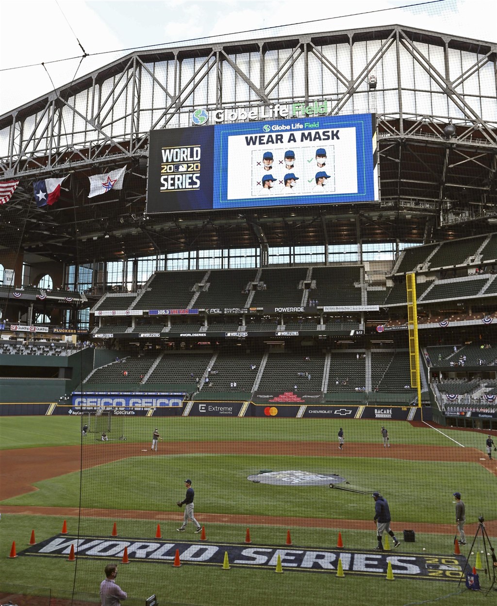 MLB世界大賽開放球迷入場,但人數嚴格管控首戰只有1萬多人進場,寫下百餘年來世界大賽觀眾最少的一次。圖為比賽場地大螢幕提醒觀眾戴口罩。(共同社)
