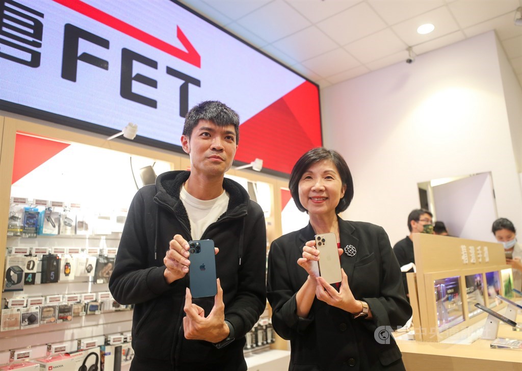 蘋果iPhone 12、12 Pro 23日在台灣正式開賣,搶到遠傳電信頭香的民眾曾先生(左)拿到到新機後,與遠傳電信總經理井琪(右)合影留念。中央社記者裴禛攝 109年10月23日