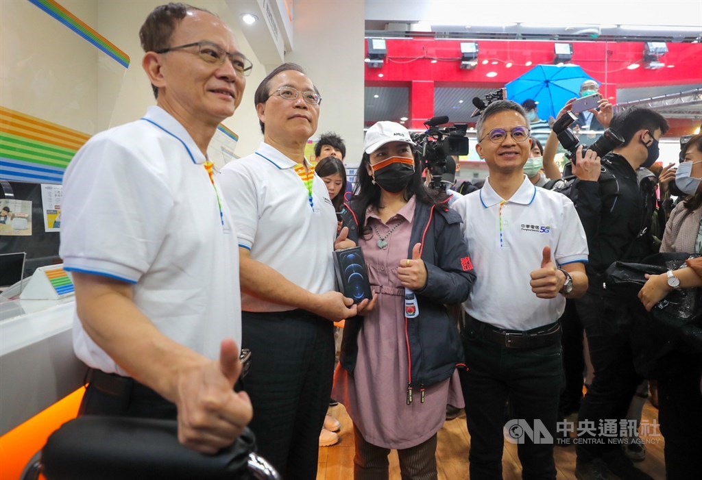 蘋果iPhone 12、12 Pro 23日在台灣正式開賣,搶得中華電頭香的客戶是從事資訊業的魏小姐(前右2),上週六就和家人輪流排隊,拿到新機後與中華電信董事長謝繼茂(前左2)、總經理郭水義(前右1)、行動通信分公司總經理陳明仕(前左1)合影留念。中央社記者裴禛攝 109年10月23日