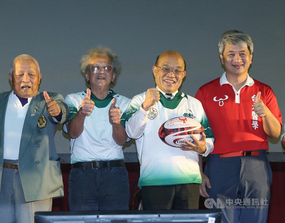 台大水牛橄欖球隊24日晚間舉行75週年慶活動,行政院長蘇貞昌(右2)出席與會,套上新球衣與過去球友開心合影。中央社記者郭日曉攝 109年10月24日