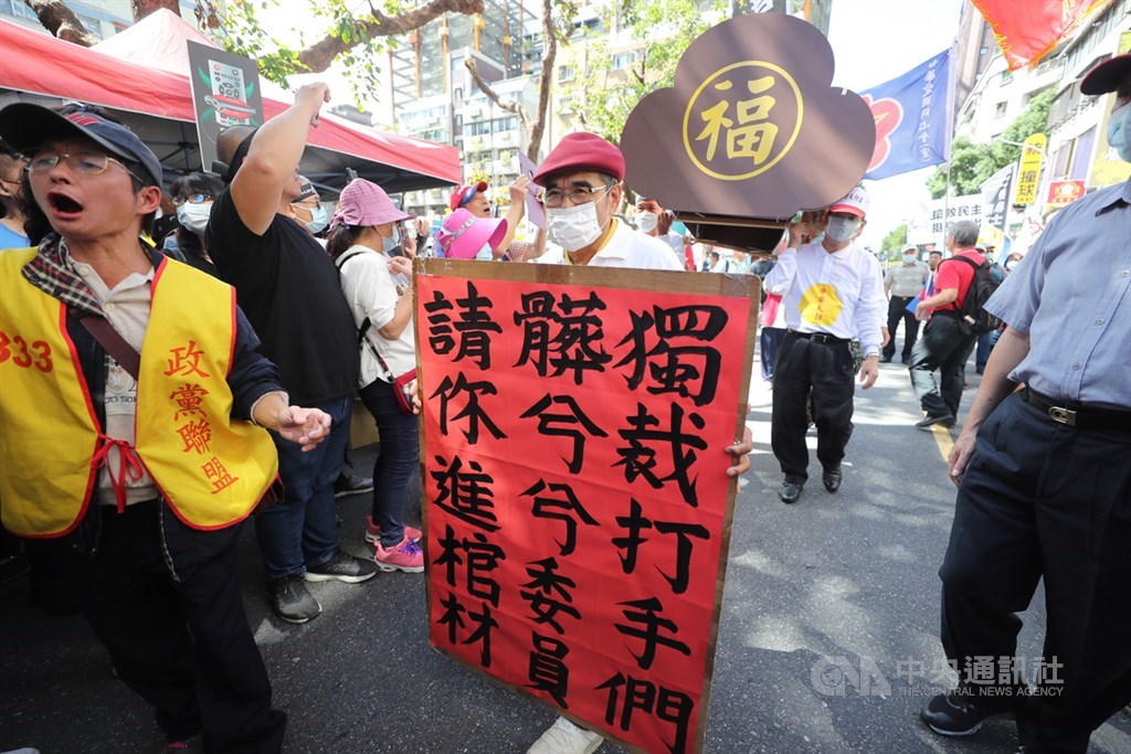 國家通訊傳播委員會(NCC)26日在台北舉行中天電視換照聽證會,支持中天的群眾集結在會場外,拿看板、呼口號,抬棺抗議。中央社記者裴禛攝 109年10月26日