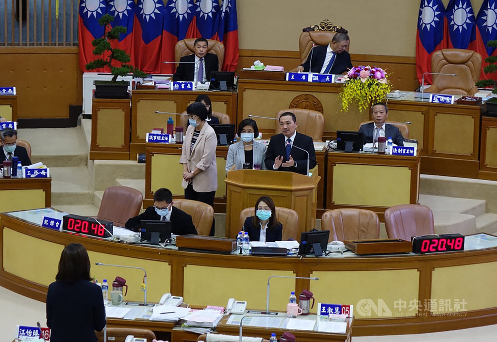新北市長侯友宜(中排立者右)30日在議會列席備詢,針對議員呼籲應讓擴大智慧停車政策,解決家長接送小孩臨停問題時表示,明年新學年下學期開始,附設公托、公幼的學校將全面實施智慧臨時停車,並結合科技執法,逾時就開單。中央社記者沈佩瑤攝 109年10月30日