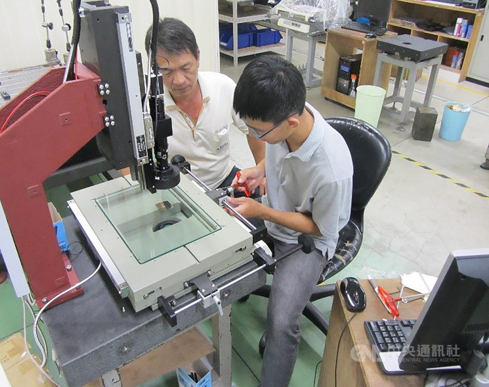 高中畢業後的陳俊廷(右)先到手機鏡頭開發與製作的公司任職,學習模具加工製作技術。(陳俊廷提供)中央社記者許秩維傳真 109年10月31日