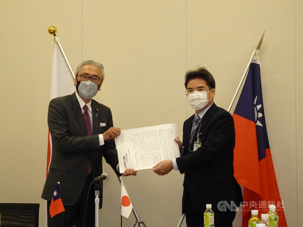 由日本超黨派國會議員組成的「日華議員懇談會」4日召開幹部會議,通過力挺台灣參與世界衛生大會的決議文。日華懇會長古屋圭司(左)將決議文交給厚生勞動省官員。中央社記者楊明珠東京攝 109年11月4日
