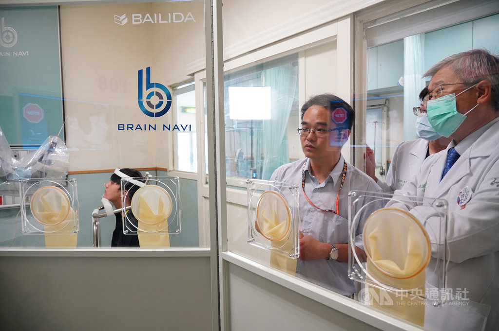 武漢肺炎疫情延燒,台灣業者鈦隼生物科技公司研發「自動鼻咽採檢機器人」,創辦人陳階曉(左)向醫護人員進行解說。(聯新國際醫院提供)中央社記者葉臻傳真 109年11月13日