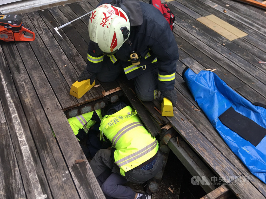 新北市消防局表示,14日下午獲報有男子不明原因自淡江大學商管學院大樓墜落,卡在木頭地板中,隨即派員前往,先以破壞器材將木頭地板鋸開,約半小時後協助多處骨折但意識清醒的傷患脫困送醫。(民眾提供)中央社記者黃旭昇新北市傳真 109年11月14日