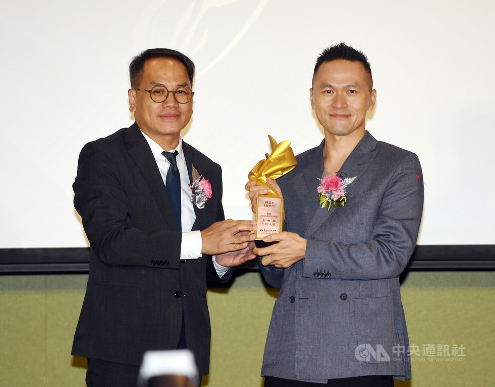 作家陳思宏(右)以故鄉為背景創作「鬼地方」,奪下2020台灣文學金典獎「金典年度大獎」,住在德國的陳思宏為贈獎典禮特地回台,14日開心自文化部次長彭俊亨(左)手中接過獎座。中央社記者施宗暉攝 109年11月14日