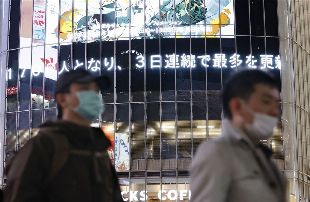 日本境內疫情延燒，14日東京澀谷街頭電子看板顯示日本確診數已連續3天創新高。（共同社）