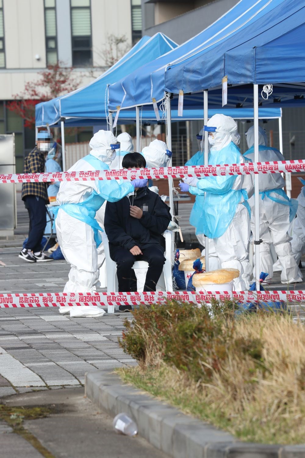 韓國近一週內武漢肺炎確診人數,每天平均增加近300例,若疫情未改善,全國社交距離規範等級可能都必須提升至第2階段。圖為濟州島一所國際學校的學生接受核酸檢測。(韓聯社)