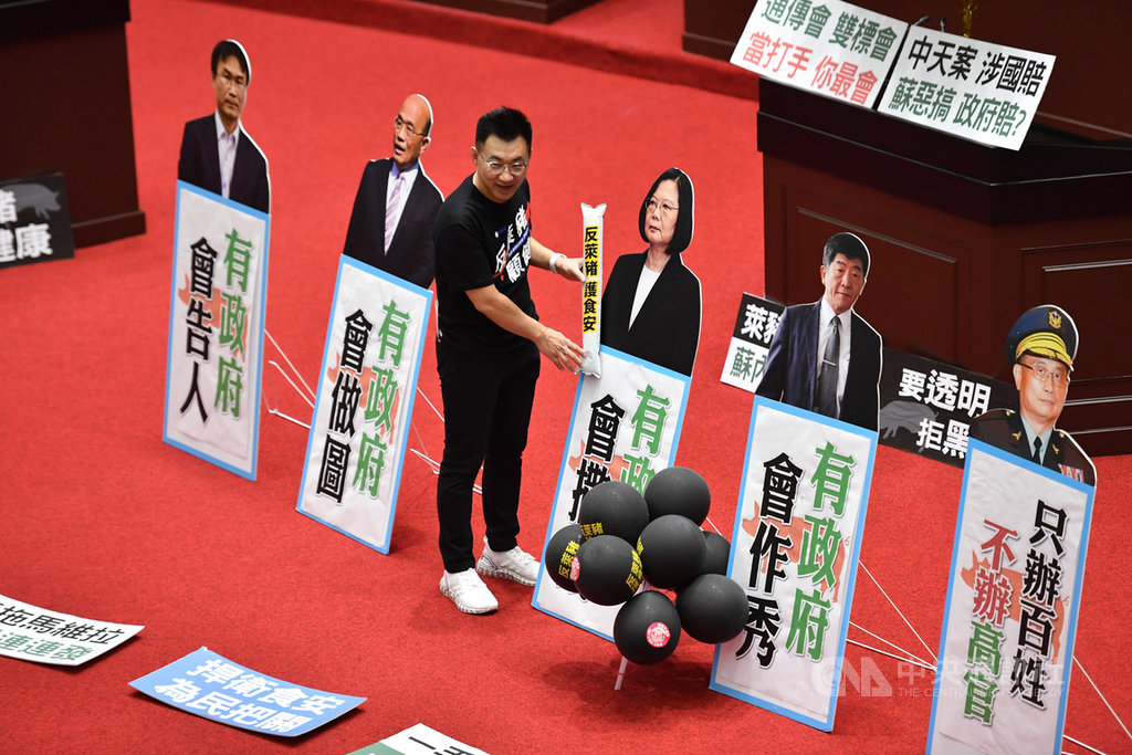 行政院長蘇貞昌20日第11度赴立法院進行施政報告並備質詢,國民黨立委不滿政府放寬萊豬進口,占據立法院議場,繼續杯葛。圖為國民黨立委江啟臣擺放總統蔡英文等人的立牌及看板。中央社記者王飛華攝 109日11月20日