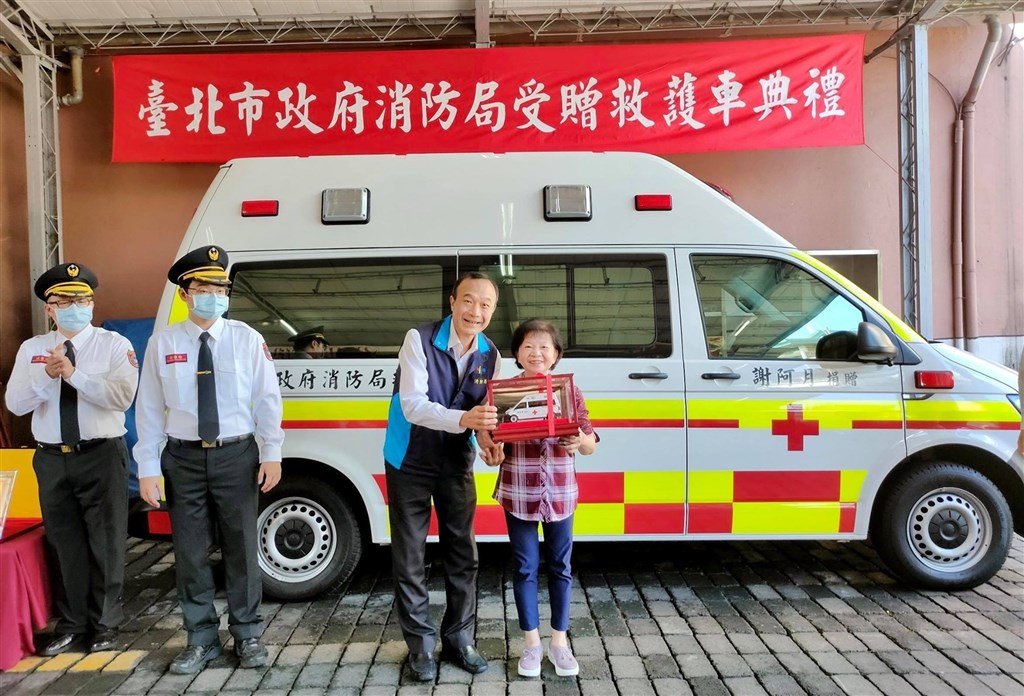 台北市消防局19日舉辦捐贈典禮,由副局長畢幼明(右2)接受開家庭理髮店的謝阿月(右1)捐贈的一輛高頂救護車。(圖取自facebook.com/119.Taipei)