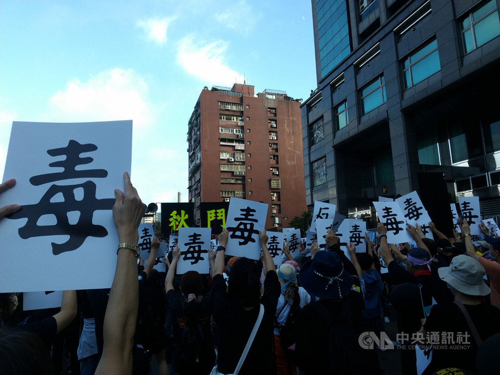 秋鬥遊行22日下午登場,遊行隊伍抵達民進黨中央黨部,民眾高舉正反面分別印有「毒」、「反」的字牌,並高喊口號,表達反萊豬訴求。中央社記者張雄風攝 109年11月22日