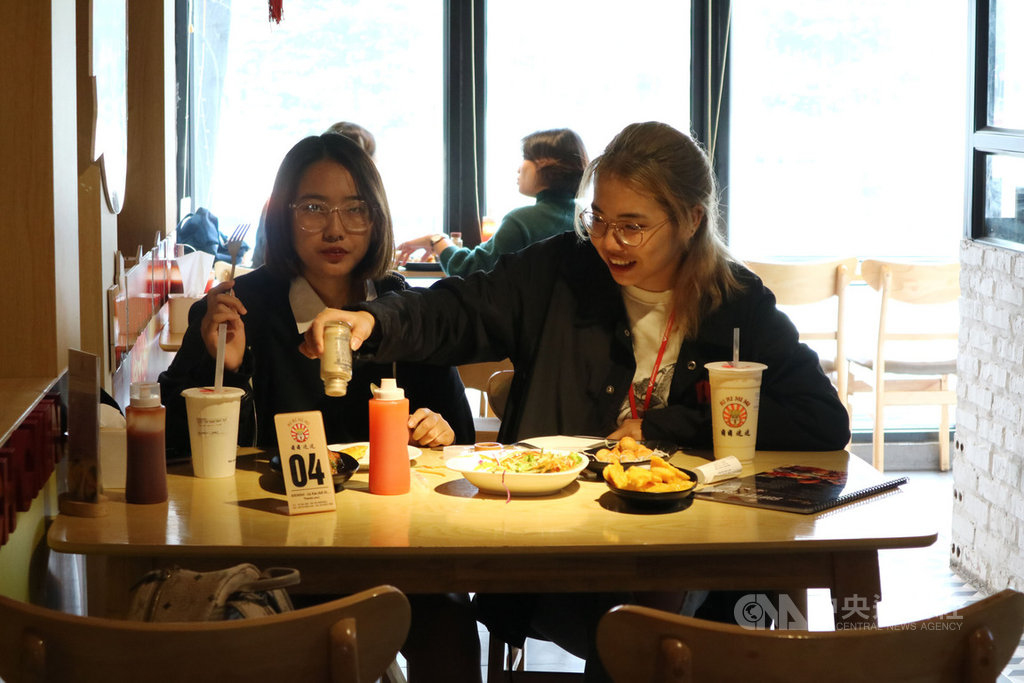 到阮德良雞排店用餐的客人,不少是曾赴台留學的越生。「吃雞排」這件事,讓他們想起早年離鄉背井的青春歲月。消費者武明英(右)曾為赴台灣的交換學生。中央社記者陳家倫河內攝 109年11月22日