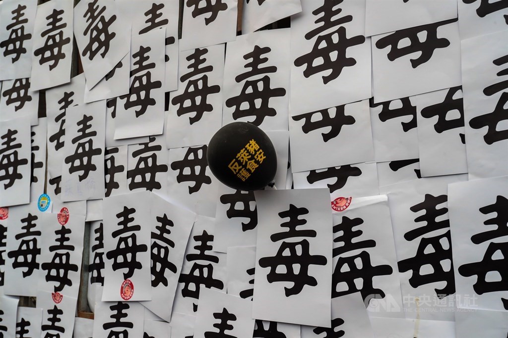 工運指標活動「秋鬥」22日登場,結合反萊豬議題吸引群眾上街響應,遊行至終點民進黨中央黨部外集結,鐵柵欄被貼滿反萊豬標語。中央社記者吳家昇攝 109年11月22日