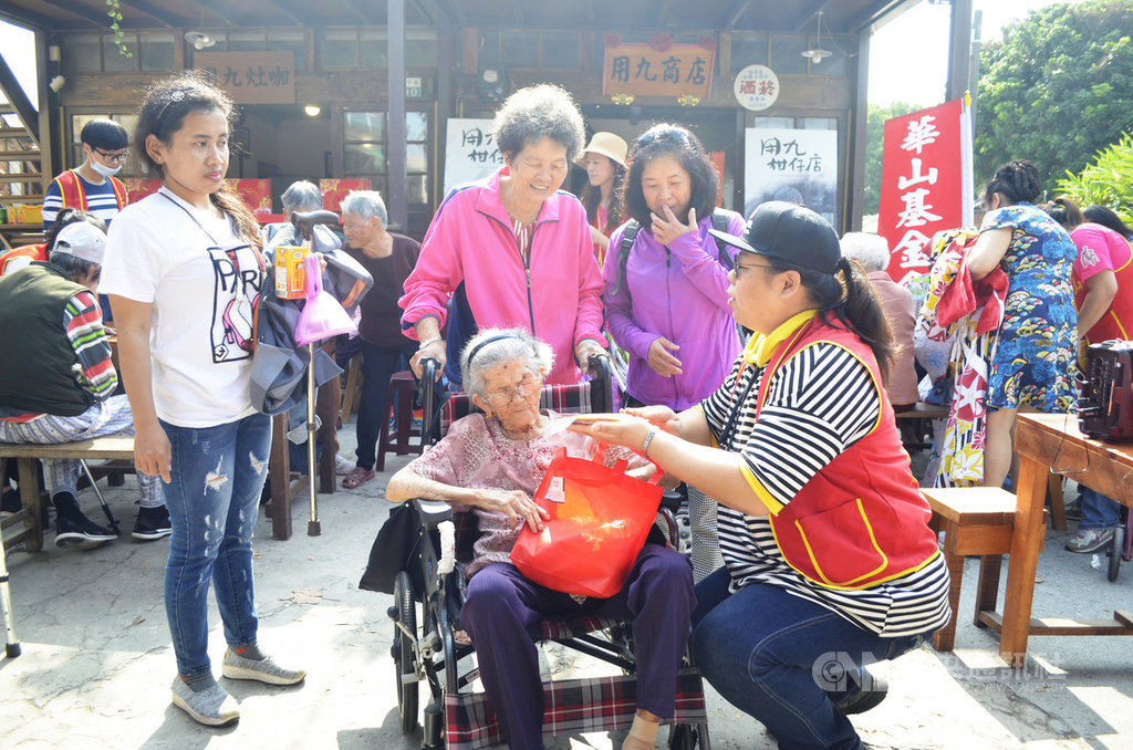 嘉義101歲人瑞鄭閩(坐輪椅者)日前向華山基金會志工表示想回六腳鄉潭仔墘娘家「用九柑仔店」附近看看,她24日完成心願,與親朋好友齊聚「用九柑仔店」話家常。中央社記者蔡智明攝 109年11月24日
