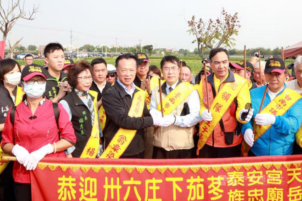 台南市後壁區泰安宮「茄苳媽」徒步遶境,25日遶境隊伍經八掌溪二橋入境嘉義縣鹿草鄉,嘉義縣長翁章梁(前右4)接駕恭迎茄苳媽,從台南市長黃偉哲(前右3)手中接過香火。(台南市政府提供)中央社記者楊思瑞傳真 109年11月25日