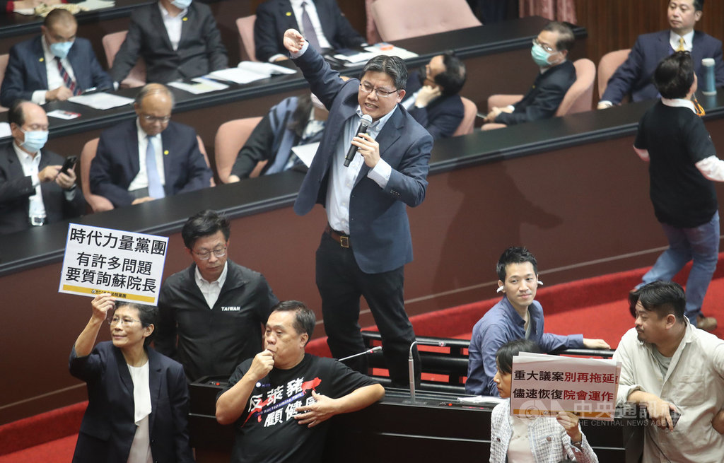 時力立委邱顯智(中)27日質詢行政院長蘇貞昌,但國民黨立委在旁干擾;邱顯智先站上椅子上質詢,更向國民黨喊話,要示範,怎樣做一個忠誠的反對黨,怎麼質詢美豬美牛議題。中央社記者張新偉攝 109年11月27日