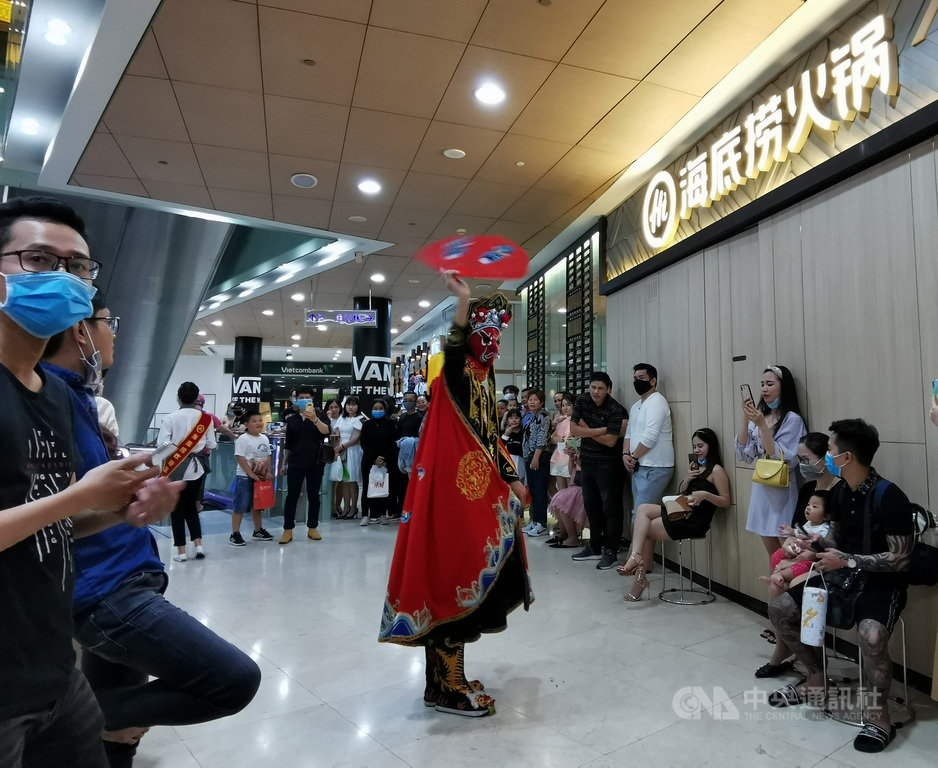 胡志明市一名英文老師在越南境內感染武漢肺炎後,當局已要求逾10萬名大學生停課在家。圖為火鍋業者在胡志明市商場中表演川劇變臉,多數民眾戴著口罩。中央社記者陳家倫胡志明市攝 109年12月1日