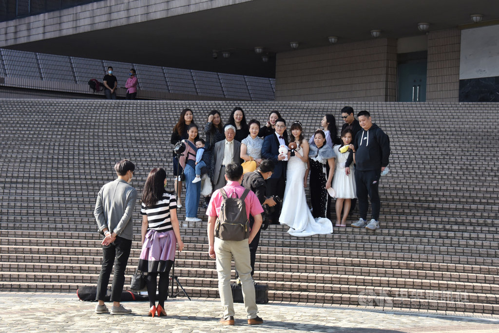 香港2日再添2019冠狀病毒疾病確診病例103例,其中有15例本土病例源頭不明。港府2日收緊多項防疫措施,規定參加婚禮不得超過20人,圖為尖沙咀文化中心有市民與親朋好友仍卸下口罩拍攝婚紗照。(中通社提供)中央社 109年12月2日