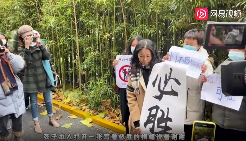 中國央視前主持人朱軍被指控於2014年涉嫌性騷擾實習生弦子,案件2日在北京海淀區法院開庭。圖為弦子到場後打開一張寫著「必勝」的海報,向眾人道謝。(截取自網易新聞)中央社 109年12月2日