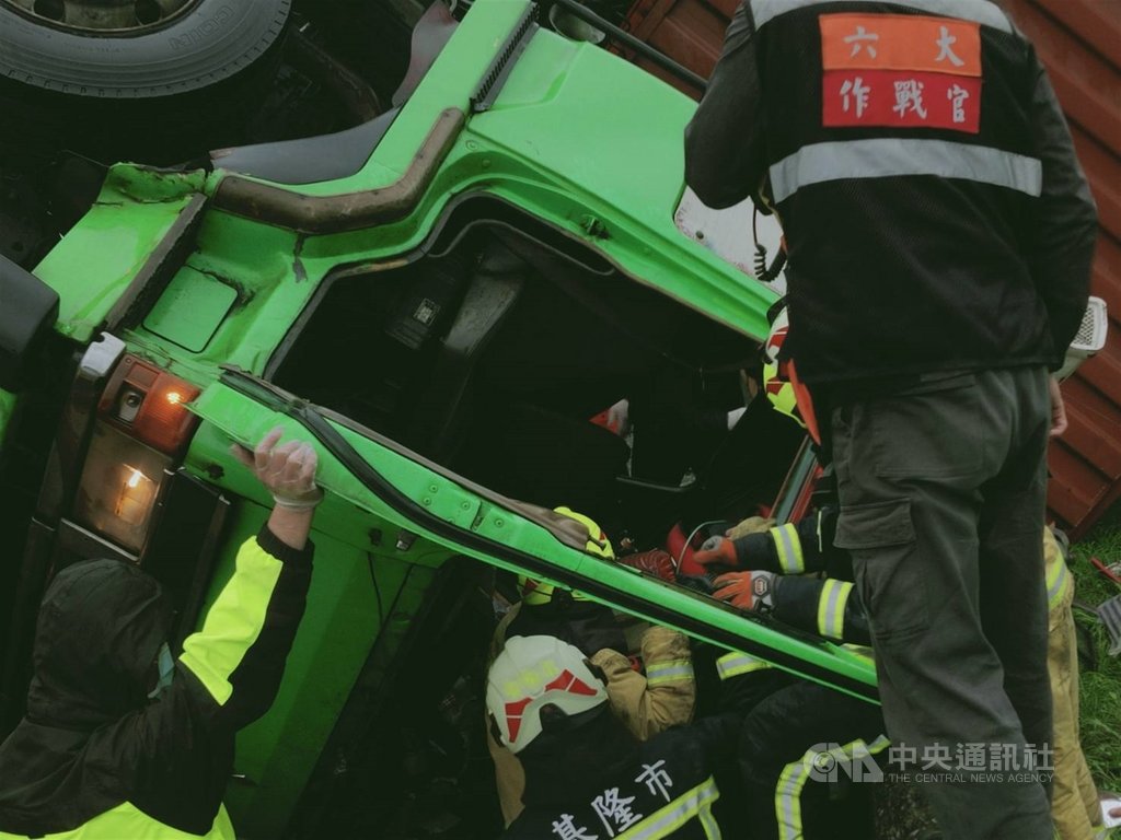 一輛聯結車4日行經瑞芳區快速道路引道時,不明原因翻覆。新北與基隆兩地消防局聯手,將受困的駕駛搶救脫困,送醫時意識清醒。(新北市府消防局提供)中央社記者黃旭昇新北傳真 109年11月4日