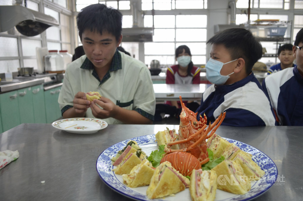 餐廳主廚朱建宇3日帶著龍蝦等食材到嘉義縣大埔國中小,義務教學生製作龍蝦沙拉,學生吃著龍蝦沙拉,露出笑容。中央社記者蔡智明攝 109年12月5日