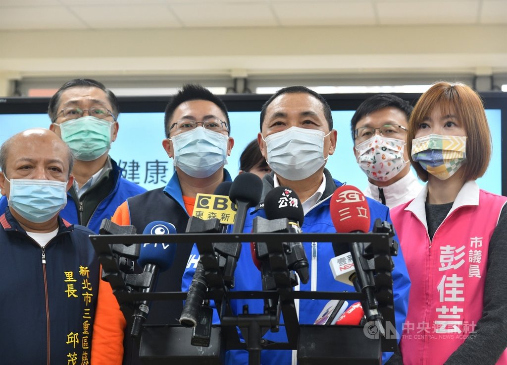 新北市長侯友宜(前右2)21日視察學校供膳配膳的過程,並在受訪時強調校園防萊豬3步驟「1看、2驗、3公告」,侯友宜表示,嚴禁萊豬滲入校園,首先就要檢視確認CAS標章及外包裝原產地。中央社記者王鴻國攝 109年12月21日