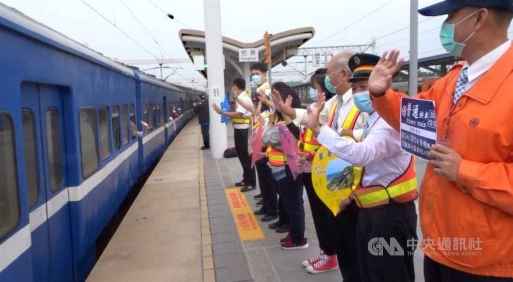 全台僅存的藍皮普快列車23日起停駛,22日最後一班列車吸引許多民眾搭乘。當列車駛出車站,台鐵人員在月台列隊,向藍皮火車揮手道別。中央社記者郭芷瑄攝 109年12月22日