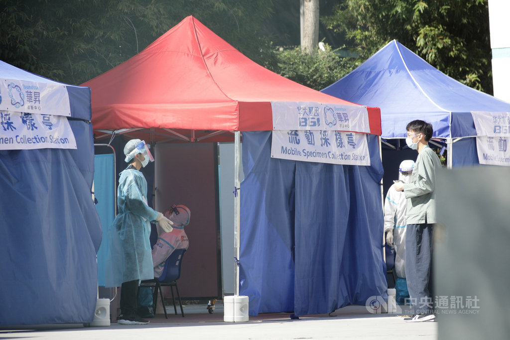 香港28日新增2019冠狀病毒疾病確診病例61例,其中,爆發群聚感染的聯合醫院再添6例確診。圖為被官方要求強制檢測的關聯民眾在聯合醫院臨時檢測中心排隊。(中通社提供)中央社 109年12月28日
