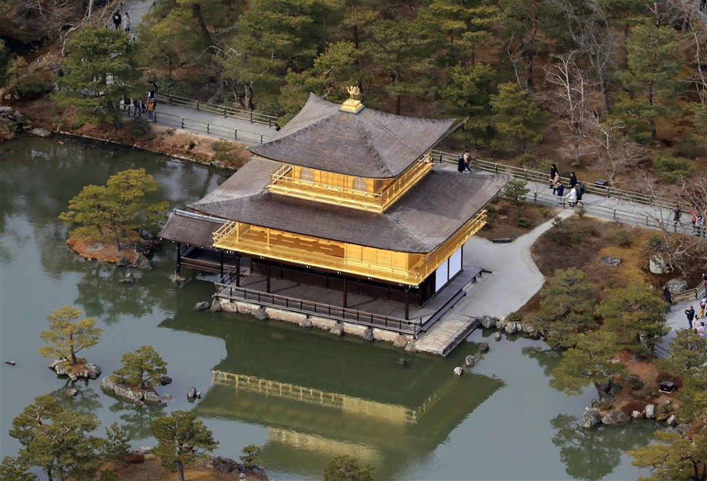 金閣是世界遺產金閣寺的代表建物,樓高3層,2樓及3樓的屋頂鋪有檜木皮,寺方考量損傷日漸增加,及疫情讓參拜人數減少,決定整修屋頂,修補作業從9月上旬展開。圖為2018年2月1日從高空拍攝金閣。(共同社)