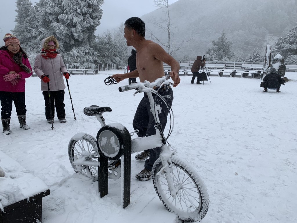 海拔約1900公尺高的太平山國家森林遊樂區因寒流下雪,8日一早已積雪3公分,遊客們欣奮不已,更有人裸上半身在雪中騎單車,玩得不亦樂乎。(羅東林管處提供)中央社記者沈如峰宜蘭縣傳真 110年1月8日