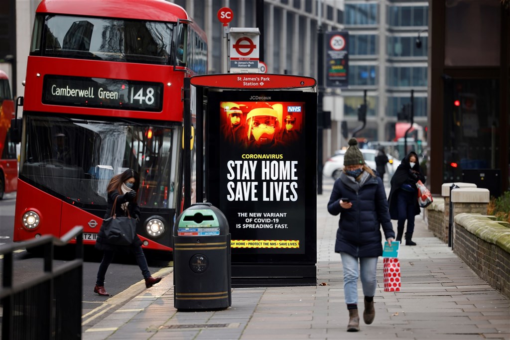 英國8日新增1325人死於武漢肺炎,是去年疫情爆發以來最高紀錄。圖為倫敦街頭看板提醒民眾疫情期間待在家裡。(法新社)