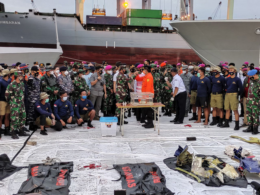 印尼一架三齊佛航空客機9日失事,印尼搜救人員12日尋獲黑盒子,印尼國軍總司令哈迪(中間左邊穿軍服者)與印尼國家搜救總署署長巴古斯(中間右邊橘色衣服者)互碰手臂表欣慰。中央社記者石秀娟雅加達攝 110年1月12日