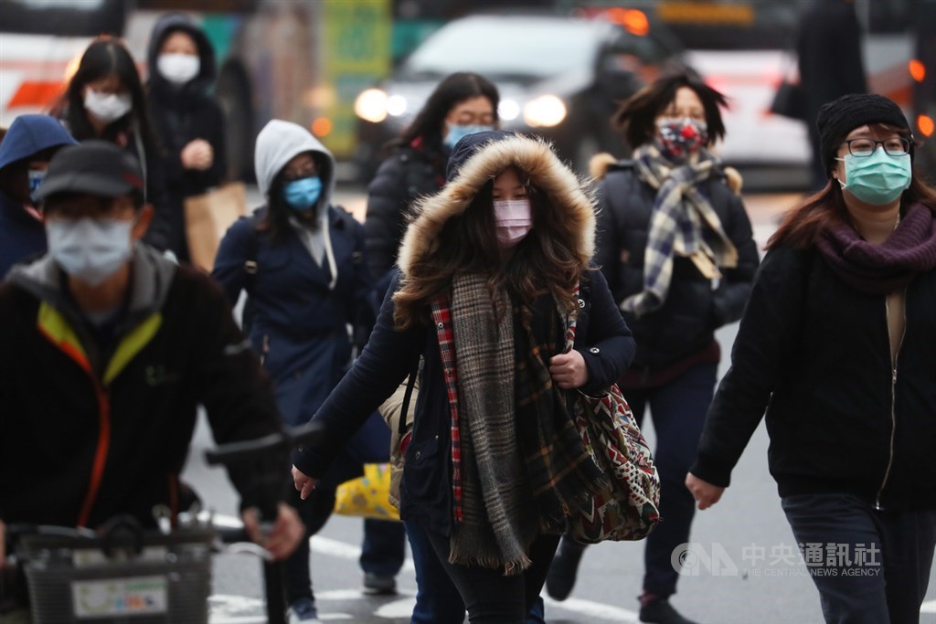 受寒流持續影響,12日各地寒冷,民眾走在街頭穿上厚外套、戴上帽子禦寒。中央社記者王騰毅攝 110年1月12日