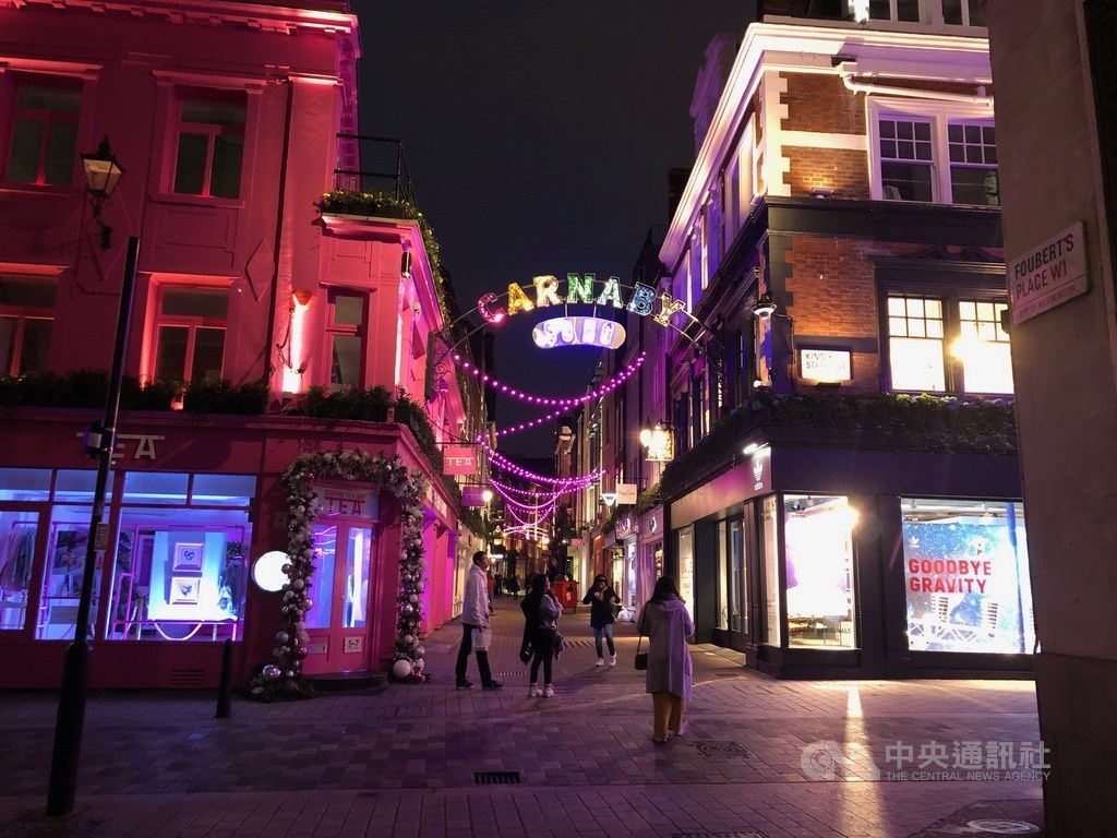 英國倫敦市長沙迪克汗13日表示,倫敦死於2019冠狀病毒疾病的人數已破萬人,呼籲英相強生祭出鐵腕,加強限制。圖為倫敦血拼一級戰區的步行街卡納比街向來摩肩擦踵,現在只有頭頂的霓虹燈閃爍。(中央社檔案照片)