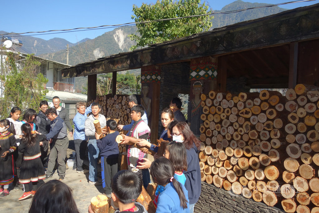 南投久美國小原有一棟布農族石板屋,因位於校園空曠處,冬季易受風寒,不利學童上課或傳統祭儀教材保存,校方規劃在石板屋外側牆面堆置圓段木,並與林務局南投林區管理處、台灣大學實驗林管理處木材利用實習工廠合作,14日和師生攜手改善布農族示範家屋。(南投林管處提供)中央社記者蕭博陽南投縣傳真 110年1月14日