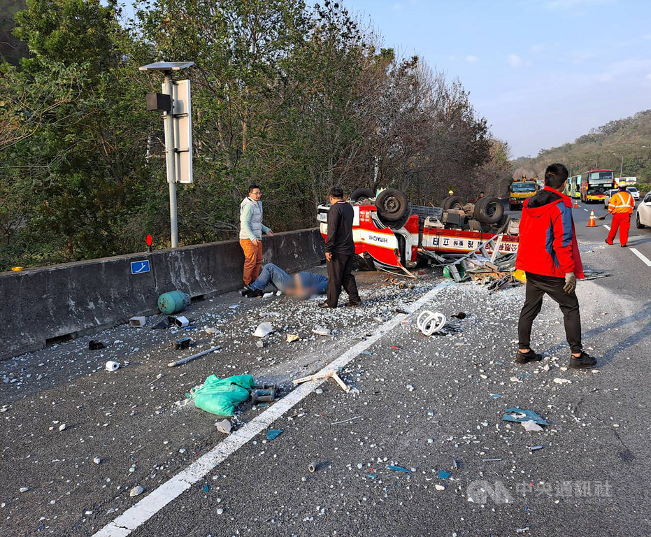 一輛冷凍空調公司小貨車16日下午行經國道一號南下125公里路段、接近頭屋交流道前約200公尺處,不明原因失控翻覆,小貨車4輪朝天打橫在路肩及外側車道,玻璃碎片及工作器材散落一地,車上2人彈甩出車外受傷送醫。(民眾提供)中央社記者管瑞平傳真 110年1月16日