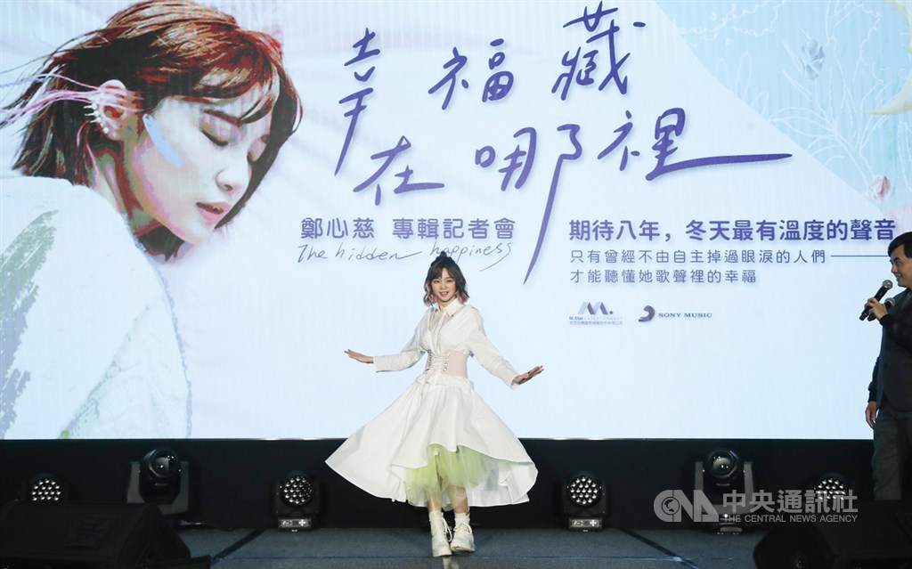 歌手鄭心慈(中)15日在台北舉辦首張個人專輯「幸福藏在哪裡」發片記者會,在記者會主持人黃子佼(右)指導下,拍攝裙擺搖曳照片,展現少女心。中央社記者張新偉攝 110年1月15日