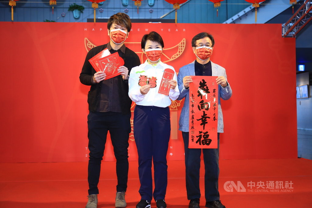 台中市政府20日舉辦新春揮毫活動,市長盧秀燕(中)展示牛年10元小紅包及春聯,祝大家牛年大吉、牛年行大運。中央社記者郝雪卿攝 110年1月20日