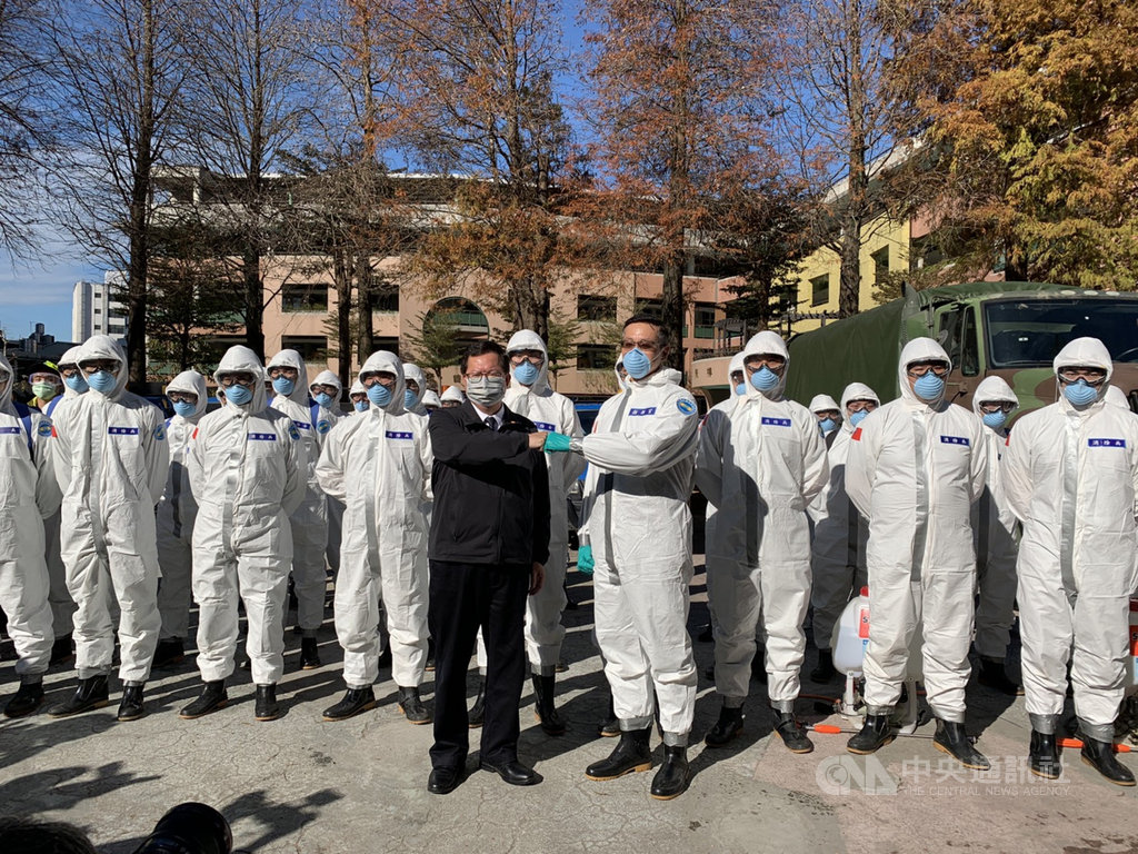 衛福部桃園醫院武漢肺炎群聚案延燒,桃園市長鄭文燦(前左)21日前往視察化學兵清消作業,與第六軍團上校指揮官龔龍峰(前右)擊拳致意。中央社記者葉臻攝 110年1月21日