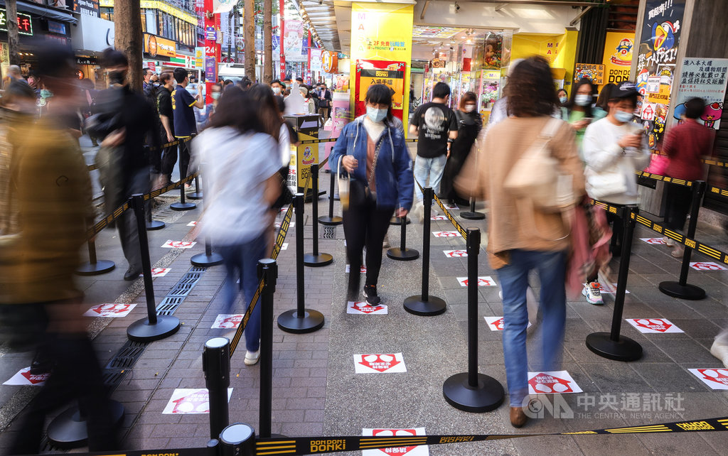 日本知名零售連鎖店唐吉訶德登台,首日吸引大批人潮引發外界擔憂,業者現已改採發放「快速通關手環」,21日下午入場時段,也有工作人員在旁提醒民眾戴口罩並按照地板標示,保持安全距離等待進場。中央社記者謝佳璋攝 110年1月21日